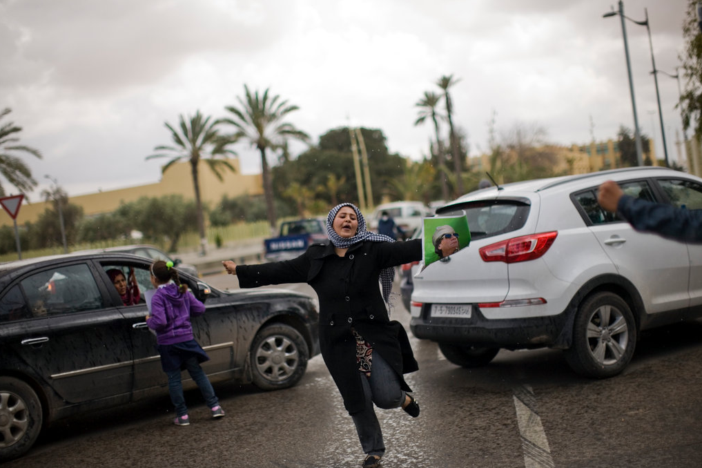Libya, Part 2. u201dA Qaddafi supporter dances and waves a picture of the Libyan leader outside a hotel in Tripoli.u201d Photo by Moises Saman, New York Times