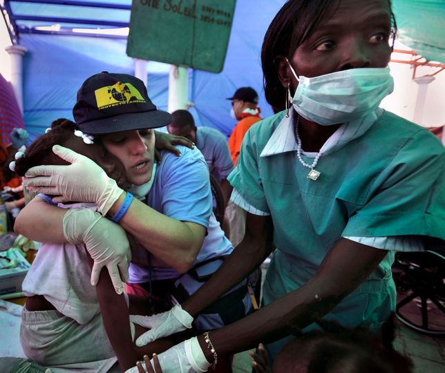 'Comfort' The medical relief teams racing to help victims of the earthquake in Haiti were up against a grim biological fact: People trapped and injured are most likely to survive if rescued within 48 hours, and very few people are found alive more than six days after a disaster. Proyecto America, a Christian disaster relief team with international volunteers, provides food and medical assistance at a camp in Cite Soleil. Nurse Marilibia Concepcion consoles Setline Premero, 8. (Carol Guzy, The Washington Post- February 1, 2010)