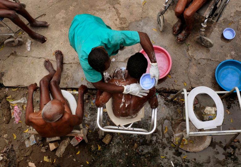 'Daily Duties' Phoncly Raphael bathes a group of men at the Azil Communal Home. Sanitation at the home remains a problem for residents living in the community. In Haitian Creole, the old are called 'gran moun,' and they are relatively few. Those 65 and older make up just 3.4 percent of Haiti's population, compared with 13 percent in a developed country such as the United States, because to attain such seniority in a nation beset by high infant mortality, poverty and disease is an accomplishment. (Nikki Kahn, The Washington Post - March 12, 2010)