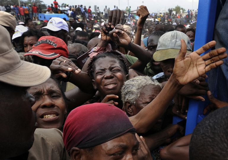 'Desperation' Frantic survivors fight to get in the gate at a food distribution center in Cite Soleil, a slum plagued by poverty even before the earthquake destroyed the area's fragile infrastructure. The United States and other countries rushed emergency stocks of aid and supplies to Haiti. Like doctors working on a dying patient, foreign governments labored to establish a kind of life-support system that would bring Haiti back. (Carol Guzy, The Washington Post - January 26, 2010)