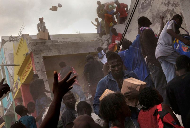 'Need' After going days without food or water, survivors take goods from a store on the main commerce street in Port-au-Prince as dust fills the air. Police assigned to control the crowd would return to scavenge for the same goods. Although a few trucks could be spotted in the capital delivering water, residents said they were becoming increasingly hungry. Many of those in need of food and medicine were children. (Nikki Kahn, The Washington Post - January 17, 2010)