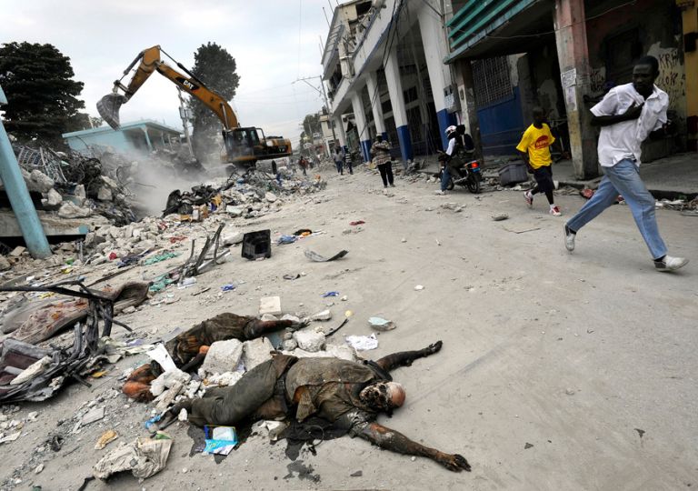 'Death' The smell of death and ash permeates the air as decomposing bodies are pulled from the rubble. For days after the quake, it was mainly the people of Port-au-Prince, working with bare hands and simple tools, who pulled at slabs of concrete and blocks of debris to get at those still trapped. Some were eventually able to get heavy machinery to tear down destroyed buildings, finding many victims who had been trapped when concrete floors collapsed. (Carol Guzy, The Washington Post - January 26, 2010)