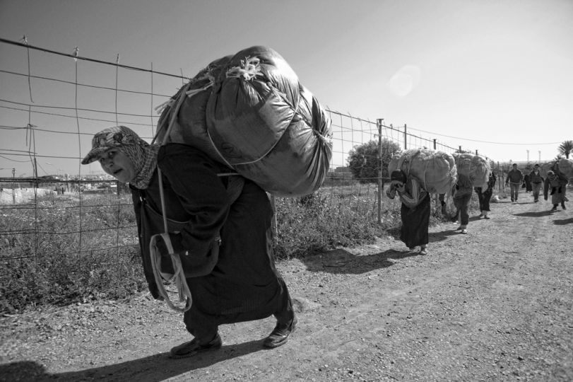 MELILLA, SPAIN - APRIL 19, 2010 : Women carrying  contraband goods up to 80 kg. in weight  to pass through Morocco in the border of  El Barrio Chino on April 19 , 2010 in Melilla. Spain. Every day at the pedestrian border of El Barrio Chino hundreds of people are involved in transporting smuggled goods from Melilla a Spanish enclave on the North African coast to Morocco.For each package introduced in morocco receive between 3 an 5 euros depending on size,with a little luck achieved make three trips a day.It is estimated that from Monday to Thursday on foot enter Melilla 8.000 porters, mostly women, to return to Morocco with huge sacks of goods from the warehouse border area of Beni Enzar in Melilla .
( Photo by Jordi Cami  )