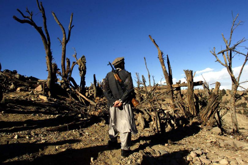  Afghanistan: Tora Bora: December 18, 2001:  An Eastern Alliance Mujahedin fighter walks through a bombed out wooded area on top of a peak in the Tora Bora mountains in eastern Afghanistan which was captured from Al Qaeda forces destroyed during a two week long siege and bombing from American war planes . Photo:Joao Silva