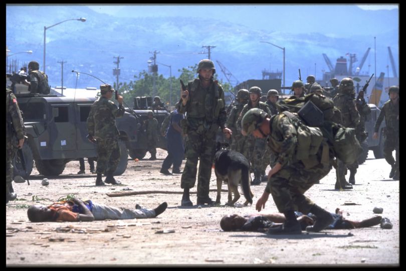 Port au Prince, Haiti. Sept. 1994.rnFollowing American intervention to rid Haiti of the military dictator, Raoul Cedras, pro-Aristidistas fall victim to a grenade attack perpetrated by agents of the F.R.A.P.H. (the tontons macoutes). American soldiers are called in to secure the area © Thomas Haley