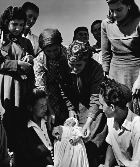 Colonie d'Alma, Galiliée du Nord, Israu00ebl,1951. Alma, près de larnfrontière syrienne, a été fondée sur une terre aride et caillouteuse par desrncatholiques du village de San Nicandro.rnConvertis, ils cohabitent avec des immigrants Juifs de Tripoli. MyriamrnTrito, la première-née du village pose dans une robe de baptême que lesrncolons ont apportée d'Italie.rn© Estate of David Seymour/Magnum Photos