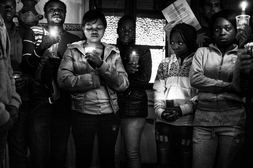 Spain, Ceuta, April 7 2012. A group of migrants from Ivory Coast is praying during an Eastern Celebration inside the headquarter of local NGO Elu00ecn. © Gianfranco Tripodo