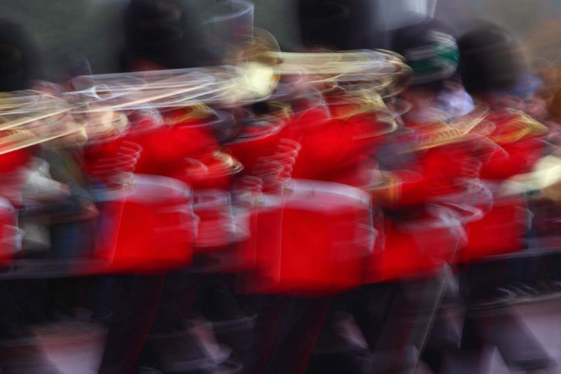 Guards band during the handover of Changing the Guard (or Guard Mounting), Buckingham Palace, London, UK. The picture captures the rythm of the soldiers on the march and the brightness of the brass instruments. © Manuel Cohen