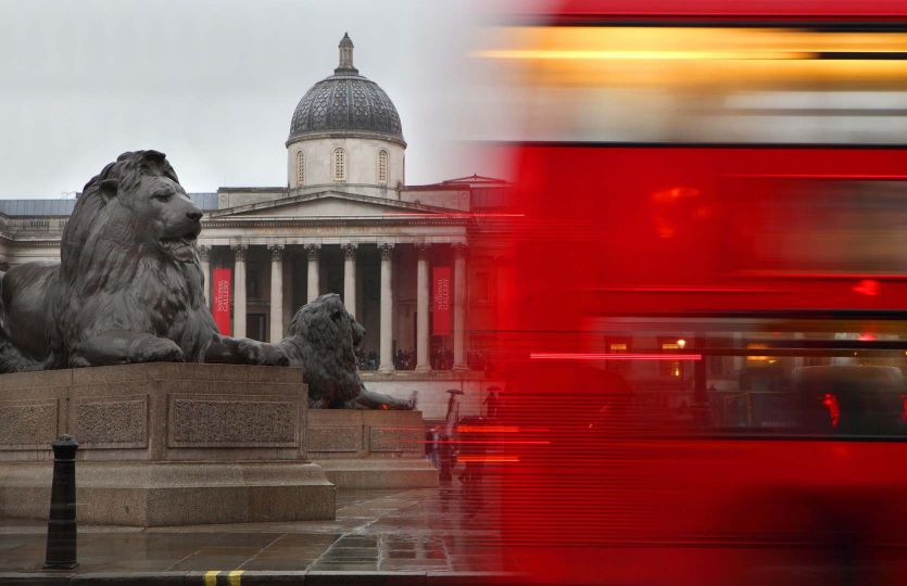Lions surrounding the Nelson's Column, 1858, by Sir Edwin Henry Landseer (1802 - 1873), National Gallery in the background, cut by a red London Bus passing on the street, London, UK. © Manuel Cohen