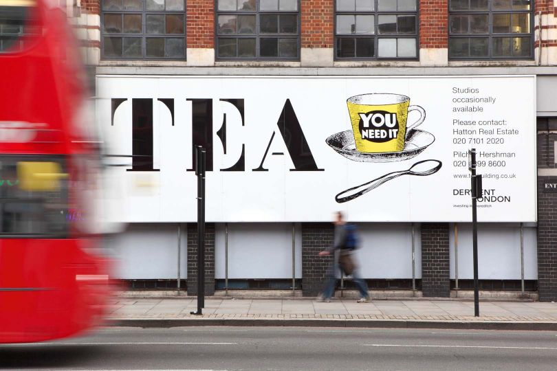 Red London bus passing through the TEA building with white display advertising for TEA, Shoreditch, London, UK. © Manuel Cohen