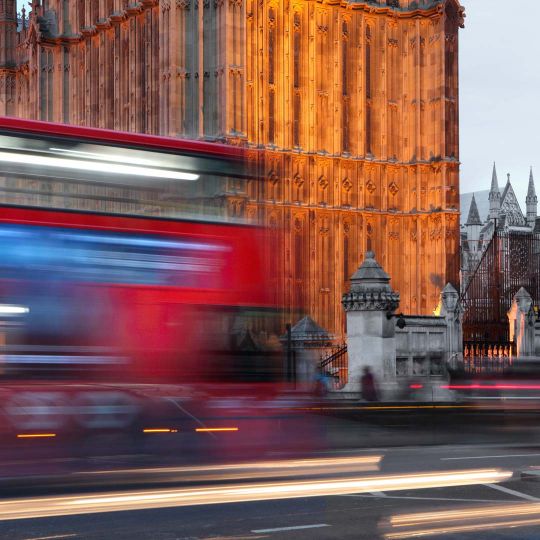 London bus against Palace of Westminster and Westminster Abbey (right) at twilight, London, UK. © Manuel Cohen