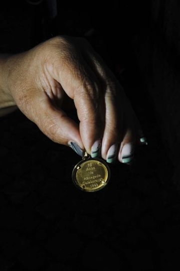 Une ouvrière montre une médaille d’or offerte par la patronne de l’usine textile Fersoni. Le 27 février, près de 90 ouvrières revenaient d’une semaine de congés imposée par la direction quand elles ont trouvées l’usine fermée. Avec des salaires en retard, elles se sont ras- semblées pendant deux semaines devant le portail de l’entreprise dans l’attente d’une explication. Au lieu de cela, le 9 Mars, elles ont reçu leur lettre de renvoi. Vila Nova de Famalicão. 09/03/2012 © Nelson d’Aires