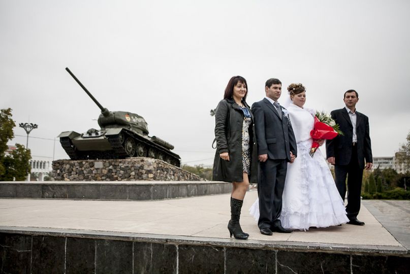 Octobre 2008. Transnistrie. Tiraspol. Mariés posant devant un char, monument militaire de la guerre de sécession contre la Moldavie en 1992. Cette place est très prisée par les habitants de Tiraspol qui viennent y flâner le week-end. © Laurent Hazgui.