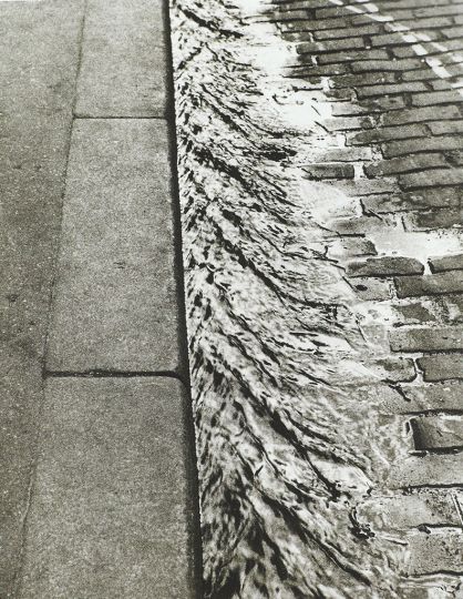 Lot 49 : Sidewalk, Paris-1929 Tirage argentique sur cartoline, vers 1960-1970. Titré, situé, daté et signé -- Sidewalk/Paris/1929/A Kertész -- au dos. Feuille  : 25,30 x 20,40 cm ; image : 24,76 x 19,60 cm. Estimation : 3 000-4 000 u20ac.