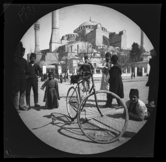 William Sachtleben’s Humber bicycle at rest in Constantinople draws a crowd of spectators.  Background: Hagia Sophia and Thomas Allen on his bicycle.  March 21, 1891.
