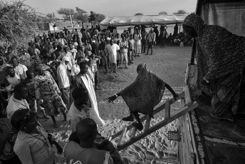 Arrivés au camp, les réfugiés descendent du camion et sont accueillis par les anciens réfugiés. © Olivier Laban-Matteirnrn