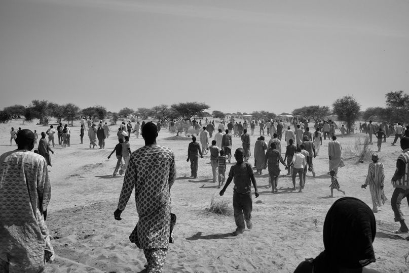 Des dizaines de réfugiés nigérians regagnent le centre du camp de Dar-Es-Salam, près du village de Baga Sola, sur les rives tchadiennes du Lac Tchad, le 8 février 2015, après s'être trompés de jour sur la distribution de leur première ration de nourriture. Ce jour-là, seules les familles de plus de 10 individus étaient servies. Les autres ont du00fb attendre le lendemain.  © Olivier Laban-Matteirnrn