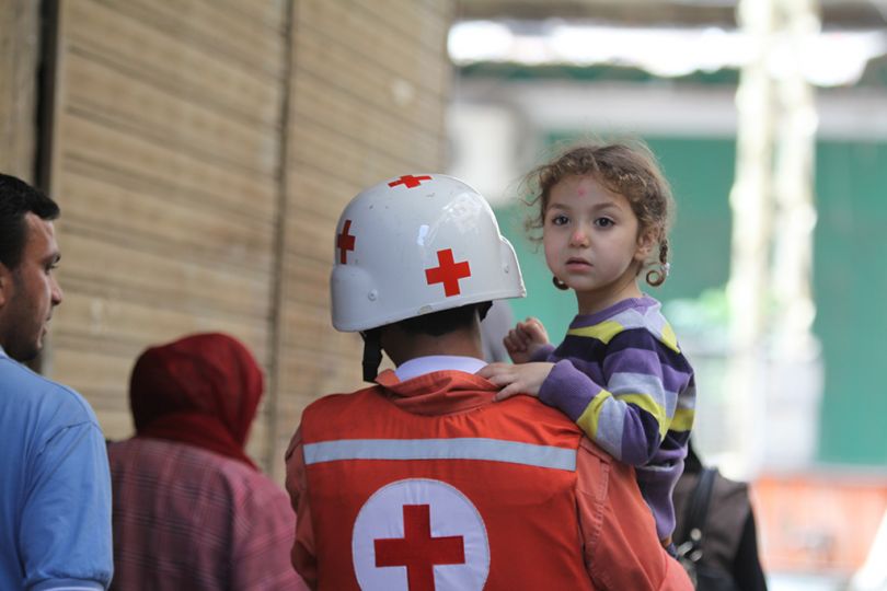 © Neyef Chehade, Lebanese Red Cross Volunteer and head of Tripoli LRC center, 2012rnAsked about my journey with the Lebanese Red Cross after 9 years of voluntary service, Nayef takes out a an old and folded page of Assafir newspaper from his  wallet.. The picture accompanying the news article shows Nayef with a little girl in his arm. It looks like he is flying. His feet are not touching the ground.  u201cThe little girl had wet herself from fear. She was not the only one who was scared, I was scared too. We all are when we're on duty. Fear is our most important defense mechanism. At a second glance, it looks like I was running very fast, between the army and combatants. Today when I look back at this picture and what happened, I am floating with happiness because I saved that child.u201drn
