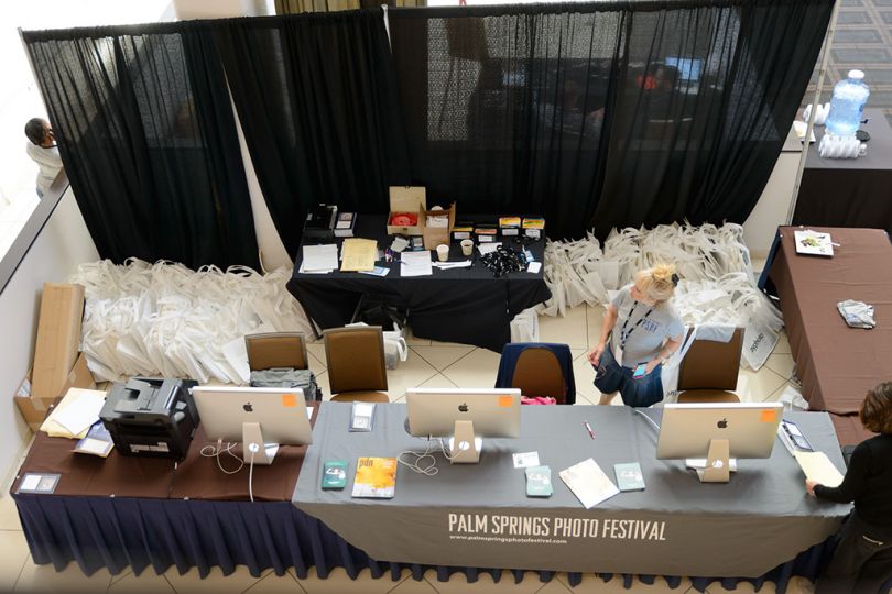Behind the counter hundreds of bags wait for arriving attendees.rn