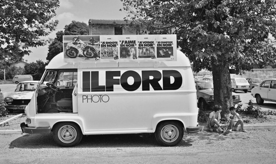 1979-Saint-Priest-ville-étape-du-Tour-de-France-avec-sa-caravanne-publicitaire,-l'usine-ILFORD-est-installée-sur-la-commune--photo-Jacques-Revon
