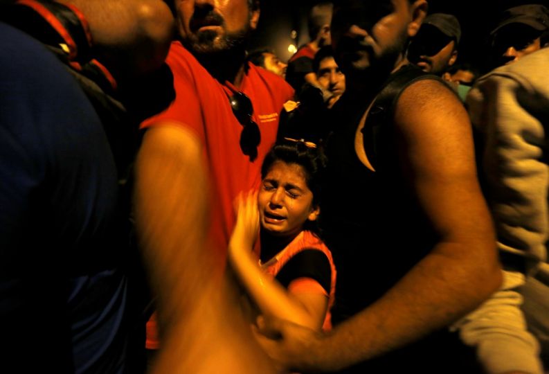 A Syrian refugee child cries as she is squeezed by other temporary stranded refugees and migrants trying to move ahead at Geece's border with FYRO- Macedonia near the village of Idomeni early morning September 7, 2015. . REUTERS/Yannis Behrakis