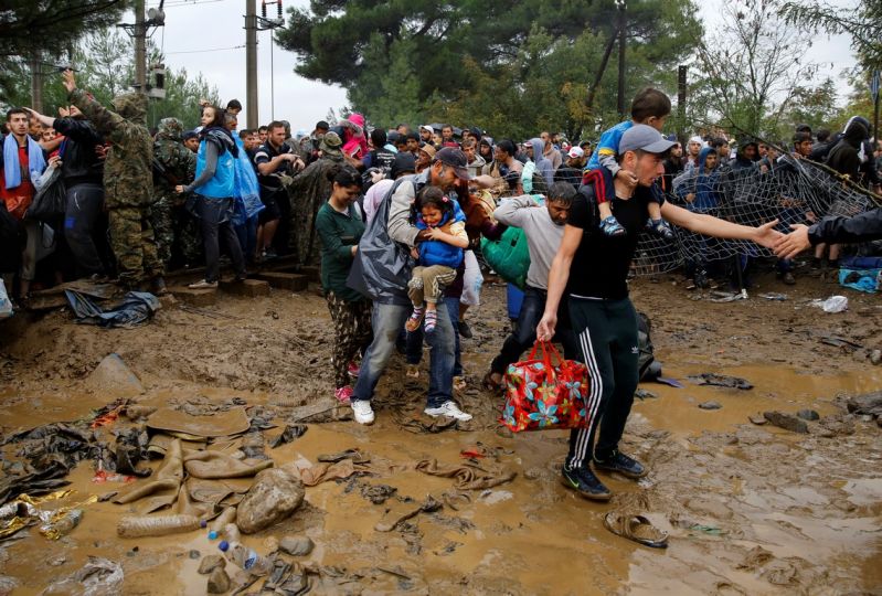 Syrian refugees walk over mud as they cross the border from Greece into FYRO Macedonia, near the Greek village of Idomeni, September 10, 2015. . REUTERS/Yannis Behrakis