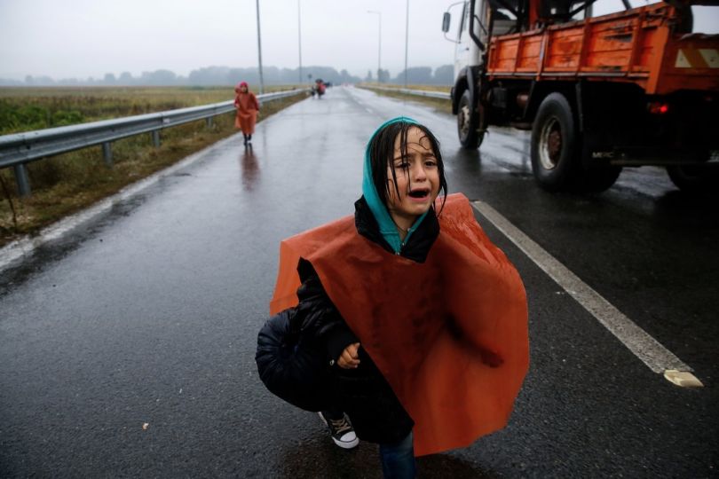 A Syrian refugee girl who was briefly separated by her parents cries as she walks through a rainstorm towards Greece's border with FYRO Macedonia, near the Greek village of Idomeni, September 10, 2015. Thousands of refugees and migrants, including many families with young children, have been left soaked after spending the night sleeping in the open in torrential rain on the Greek- FYRO Macedonian border. About 7,000 people waited in the mud of an open field near the northern Greek village of Idomeni to cross the border, with more arriving in trains, buses and taxis, as FYRO Macedonian police has imposed rationing in the flow of refugees.