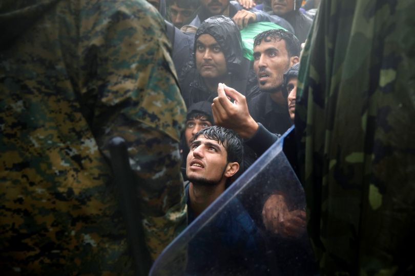 Migrants and refugees beg FYRO Macedonian policemen to allow passage to cross the border from Greece into FYROM during a rainstorm, near the Greek village of Idomeni, September 10, 2015.Thousands of refugees and migrants, including many families with young children, have been left soaked after spending the night sleeping in the open in torrential rain on the Greek- FYRO Macedonian border.. Yannis Behrakis/REUTERS