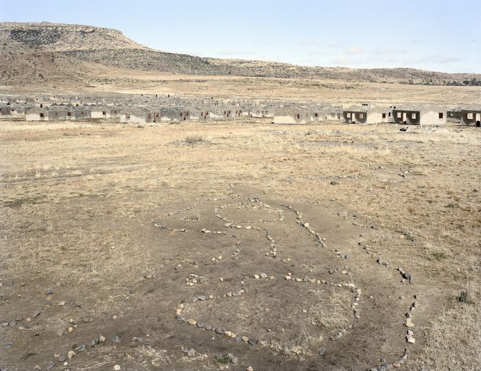 David Goldblatt, Remains of households in a children's game called onopopi, and the shells of incomplete houses in a housing scheme that stalled, Kwezinaledi, Lady Grey, Eastern Cape. 5 May 2006