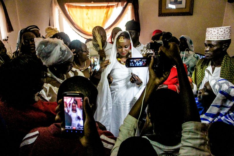 Kibera: Stories From Within © Brian Otieno 1st Place - During a wedding ceremony, friends and family take photos with Fatma - a Nubian newlywed bride, inside her parent’s house in Kibera, when she was visited by the groom for the first time after tying the knot.