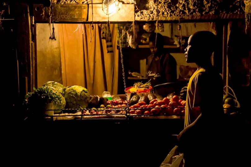 Kibera: Stories From Within © Brian Otieno 1st Place - A boy shops for the night time meal at a grocery kiosk in Kibera. In most business stores, the owners usually live on the inner part of the house and sell their items on the front part, usually near a busy street or road.