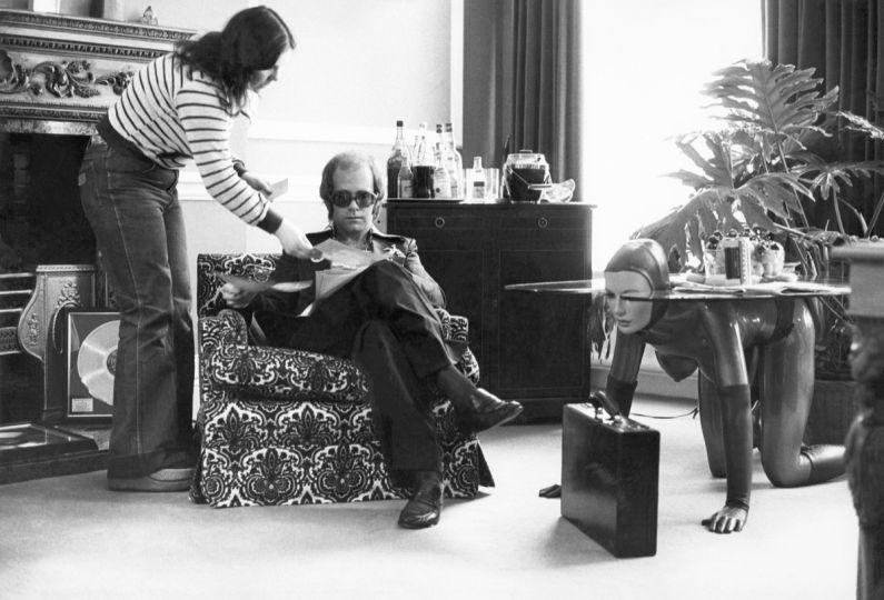Elton John - In his office, mid 1970s © Terry O’Neill / Iconic Images