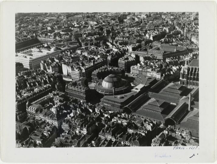 La bourse de Commerce et les halles centrales. 1er et 2ème arrondissements. Vue aérienne oblique vers le Nord-Ouest. Secteur : Banque de France, rue du Louvre, rue Berger, rue Saint-Honoré. 1949. Photographie de Roger Henrard (1900-1975). Paris, musée Carnavalet.