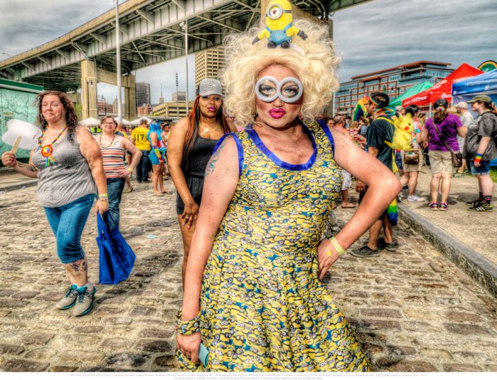 4. Her Dress Was Printed with a Pattern of Cartoon Characters Called “Minions,” From the Universal Pictures’ Cartoon “Despicable Me.” One Wondered if She Knew the Meaning of the Word Minion: A Follower or Underling of a Powerful Person, Especially a Servile or Unimportant One. Pride Parade Festival at Canalside, June 7, 2015. © Les Krims