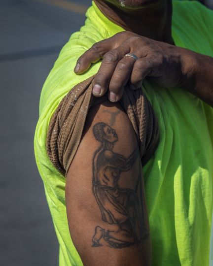 Sir Bailey’s abolitionist tattoo, photographed on West Genesee Street, Syracuse. Originally designed in 1787 as a
medallion for the British anti-slavery campaign, this image was later appropriated by the American abolitionist
movement. © Nicola Lo Calzo – Courtesy Light Work