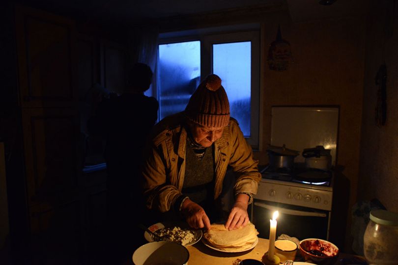 Masha dans sa cuisine, il est 16h 30 la nuit tombe, sans éléctricité, elle s’éclaire à la bougie afin de pouvoir cuisiner. Bakhmoutka, Est de l’Ukraine, novembre 2016. © Péhée Marion