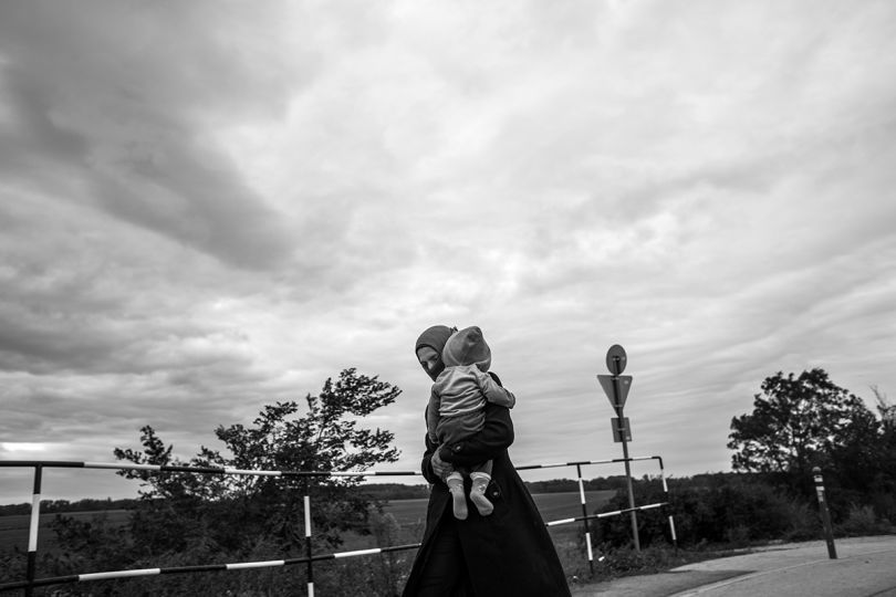 Une femme et son enfant marchent entre la Hongrie et l’Autriche. Il faut parcourir sept kilomètres pour rallier la première ville autrichienne. Hongrie. Septembre 2015. © Michael Bunel