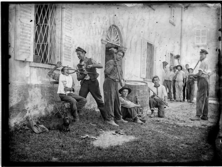 Roberto Donetta 
Scène apprêtée ; groupe d’hommes devant un bâtiment
1900-1932/1993
Tirage argentique sur papier baryté, virage au sulfure de sodium 
Photo 30 × 40 cm
Musée d’art de la Suisse italienne, Lugano. Collection du Tessin
