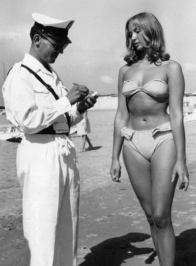 Un policier dressant un procès-verbal à une jeune femme en bikini. Rimini (Italie), septembre 1957. © Ullsteinbild © Ghislaine Rayer & Patrice Gaulupeau – Courtesy BikiniARTmuseum