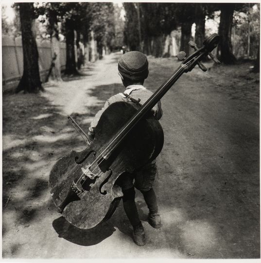 Lot 14 : BESNYÖ, Eva (Dutch, Hungarian 1910 - 2003). Zigeunerjongen met cello bij het Balatonmeer, Hongarije [Boy with cello near Lake Balaton, Hungary], 1931.