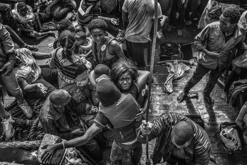 Migrants on board a wooden fishing vessle carrying over 500 people and sailing from Libya are transferred onto the MSF Bourbon Argos. 26 August 2015. © Francisco Zizola