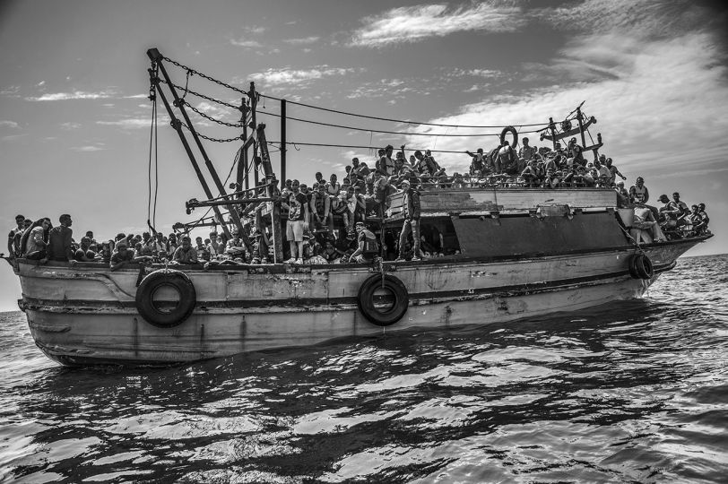 A wooden fishing vessle sailing from Libya and carrying more than 500 migrants is apprached by the MSF Bourbon Argos search and rescue ship. 26 August 2015. © Francisco Zizola 