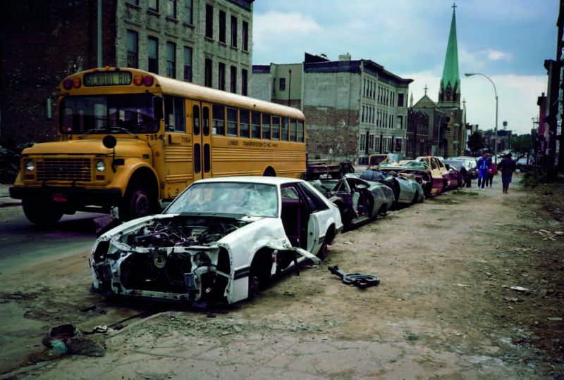 School Bus and Curbside Crushed Cars Palmetto St., Bushwick, Brooklyn, NY. May 1985 © Meryl Meisler – Courtesy Parallel Pictures Press 2021