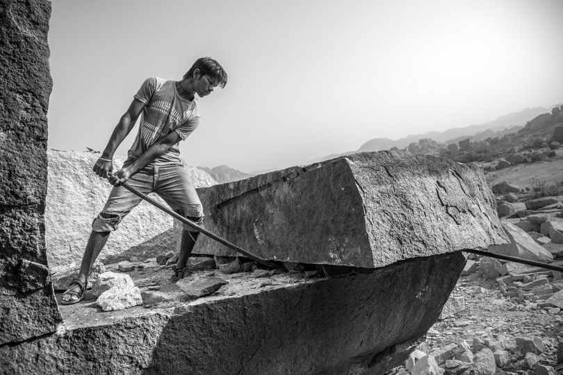 A work in a granite quarry, leveraged with a crowbar to make a rock fall, India 2015.
Un travailleur dans une carrière de granites fait levier avec un pied-de-biche pour faire tomber un rocher, Inde 2015. © Fabien Dupoux