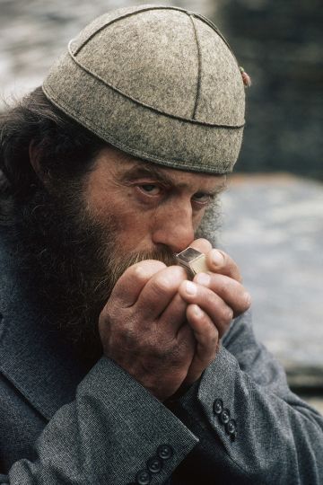 Oujgouli, le gardien du tresor de l'eglise allume sa cigarette et nous toise, pour savoir si nous avons droit a la decouverte du tresor. Svanetie. Georgie. Caucase. © Marc Garanger