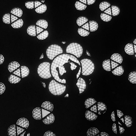 Rosace et ouvrier en contre-jour à la Cathédrale Notre-Dame de Paris, 1935. © Gaston Paris / Roger-Viollet