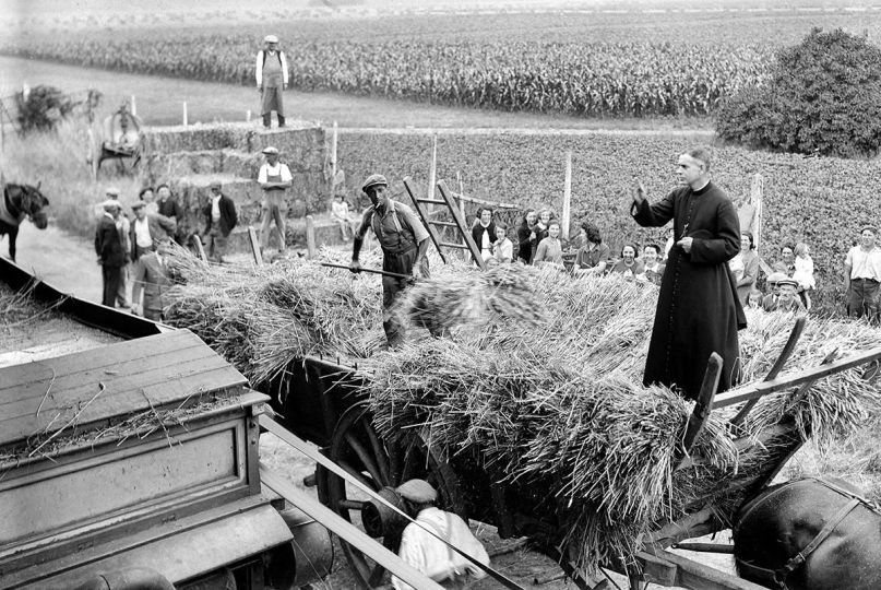 Guerre 1939-1945. Battage du blé en Seine-et-Marne. Prêtre bénissant la moisson. Juillet 1943. © LAPI / Roger-Viollet