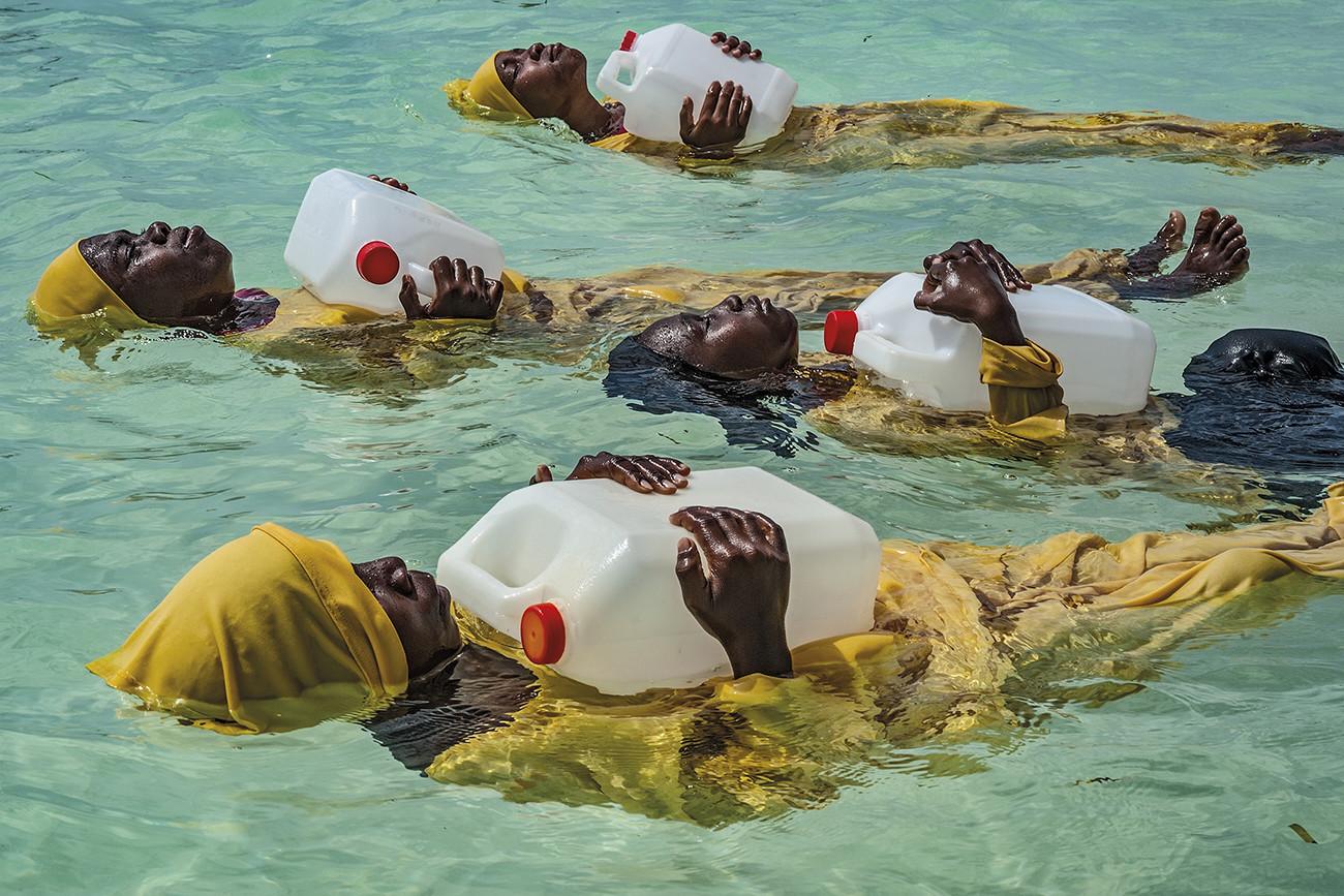 color photograph of women in full length swim suits learning to float and swim in Zanzibar