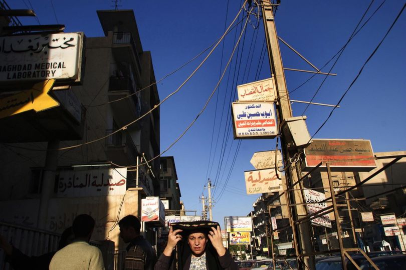 BAGHDAD, IRAQ, 2003 A woman adjusts her veil as she walks through the Bataween district of central Baghdad. © Ed Kashi - Courtesy Kehrer Verlag