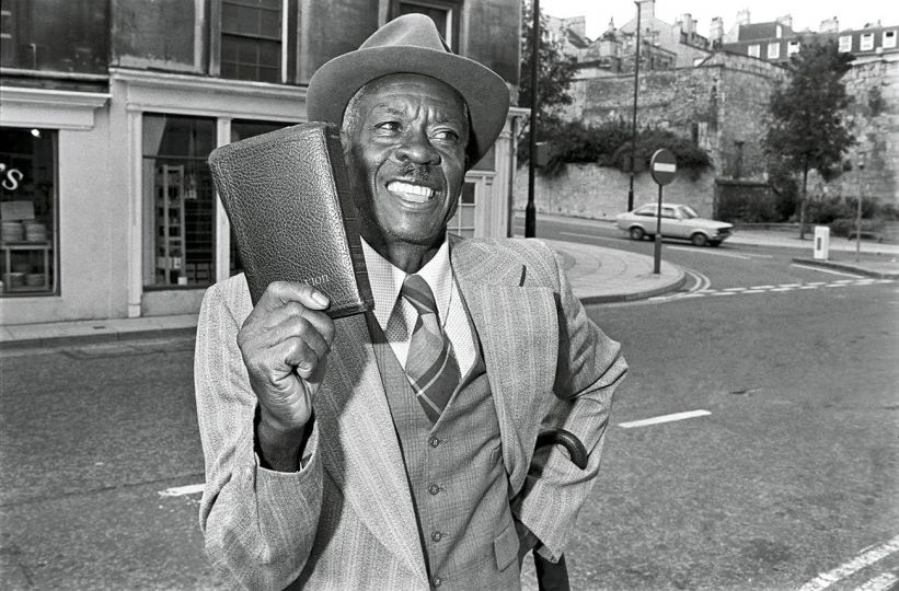 BATH, ENGLAND, 1977 A Jamaican minister preaches the Bible to passersby in Bath, England. © Ed Kashi - Courtesy Kehrer Verlag